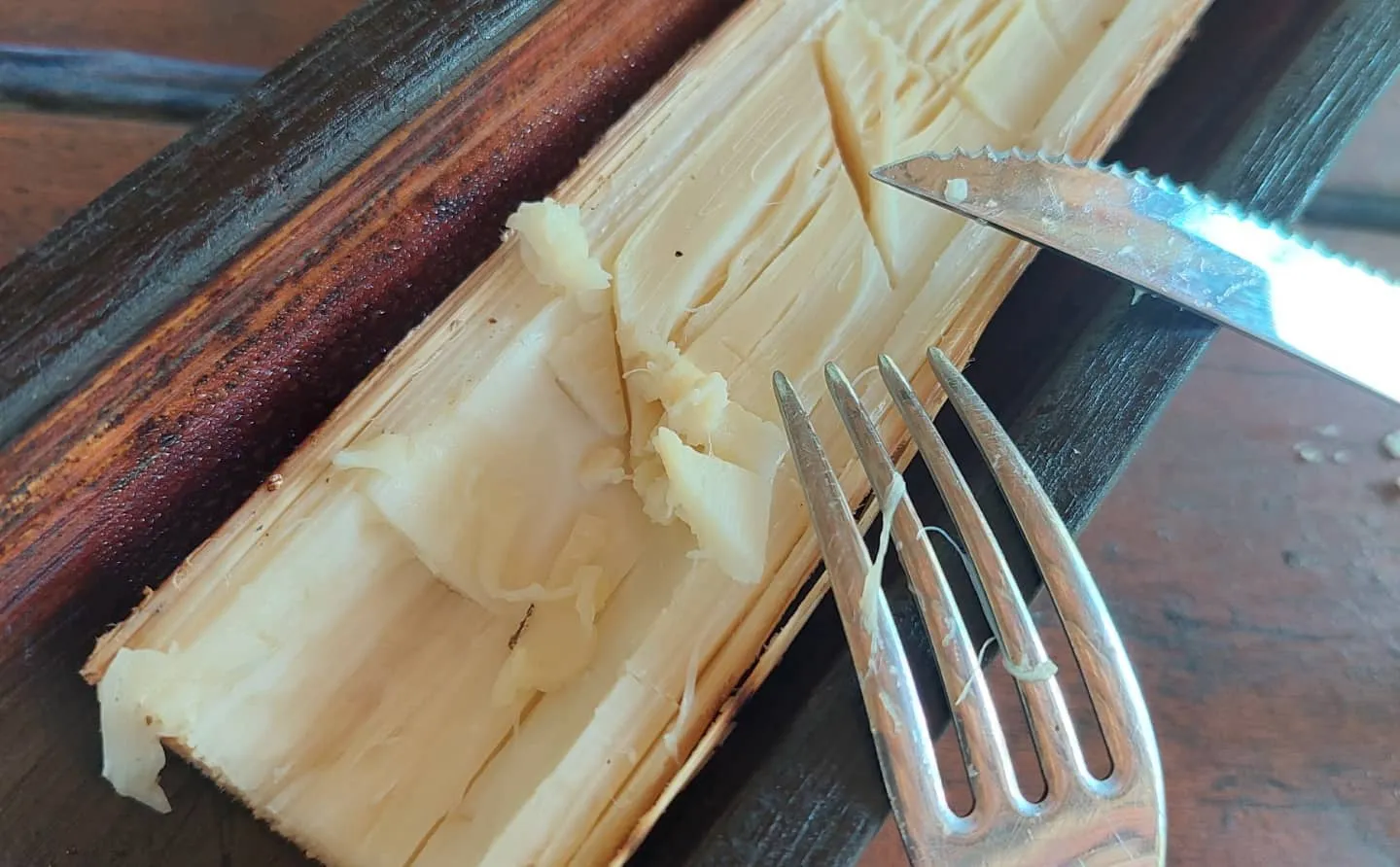 Garfo e faca servindo o palmito assado direto da casca